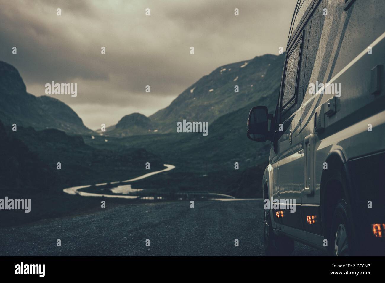 Road Trip Mit Einem Freizeitfahrzeug. Camper Van RV der Klasse B an einer verregneten skandinavischen Straße. Urlaubszeit Schlechtes Wetter Thema. Stockfoto