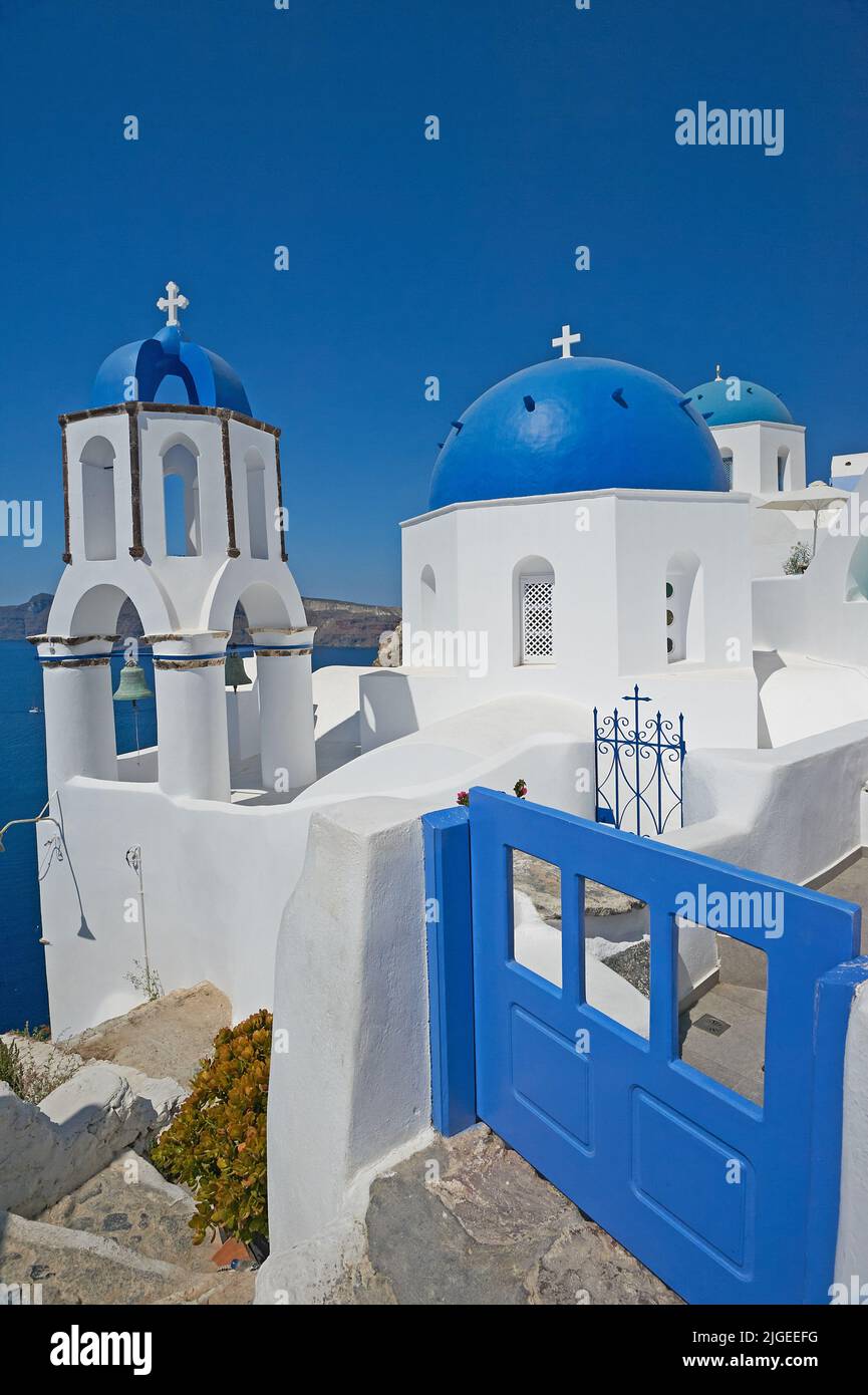 Traditionelle griechisch-orthodoxe Kirchen mit blauer Kuppel in Oia oder Ia auf der Insel Santorini, die zu den Kykladen-Inseln vor dem griechischen Festland gehört Stockfoto