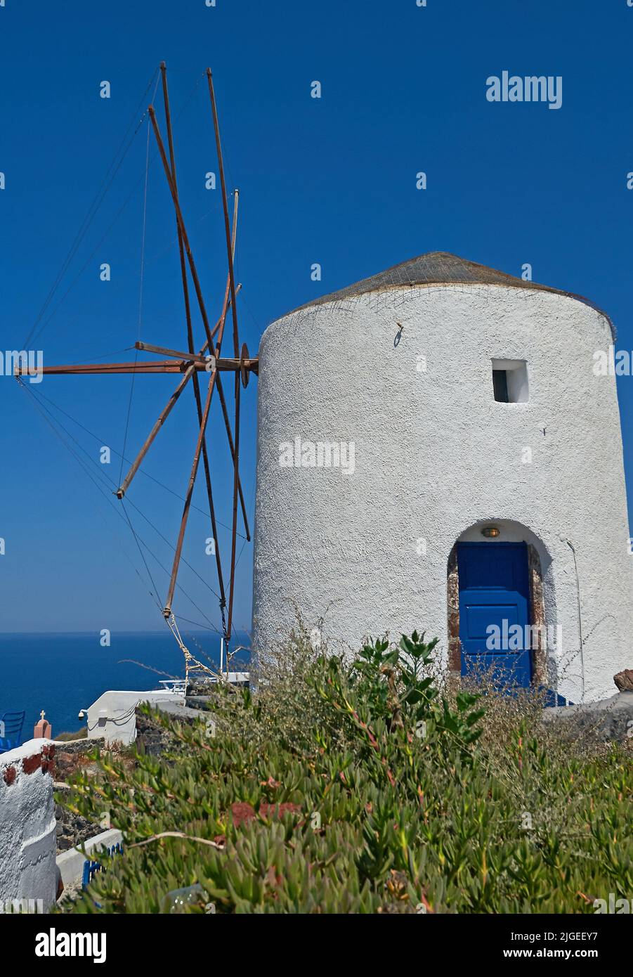 Oia oder Ia und eine weiß gewaschene Windmühle auf der Insel Santorini, die zu den Kykladen-Inseln vor dem griechischen Festland gehört Stockfoto