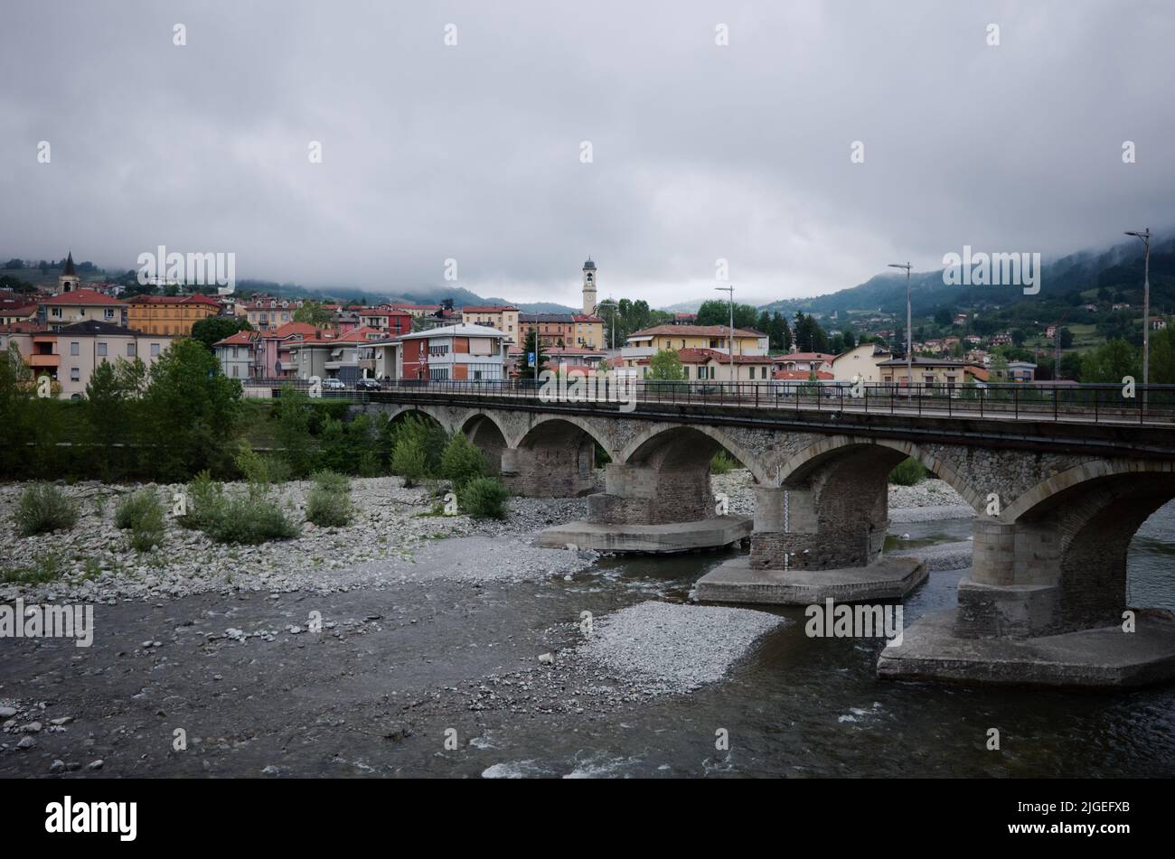 Borgo Val di Taro, Italien - Mai 2022: Panoramablick auf die Stadt Borgotaro bei Regen. Brücke über den Fluss Taro, Stadtbild des italienischen Dorfes Stockfoto