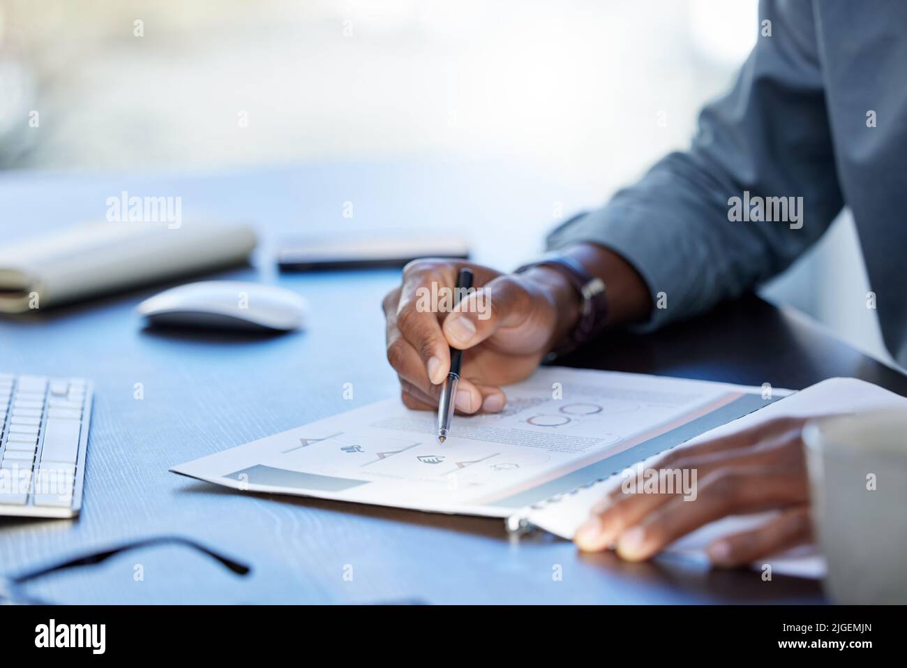 Die erfolgreiche Person ist der durchschnittliche Mann. Ein unkenntlich Geschäftsmann, der Papierkram in einem Büro bei der Arbeit macht. Stockfoto