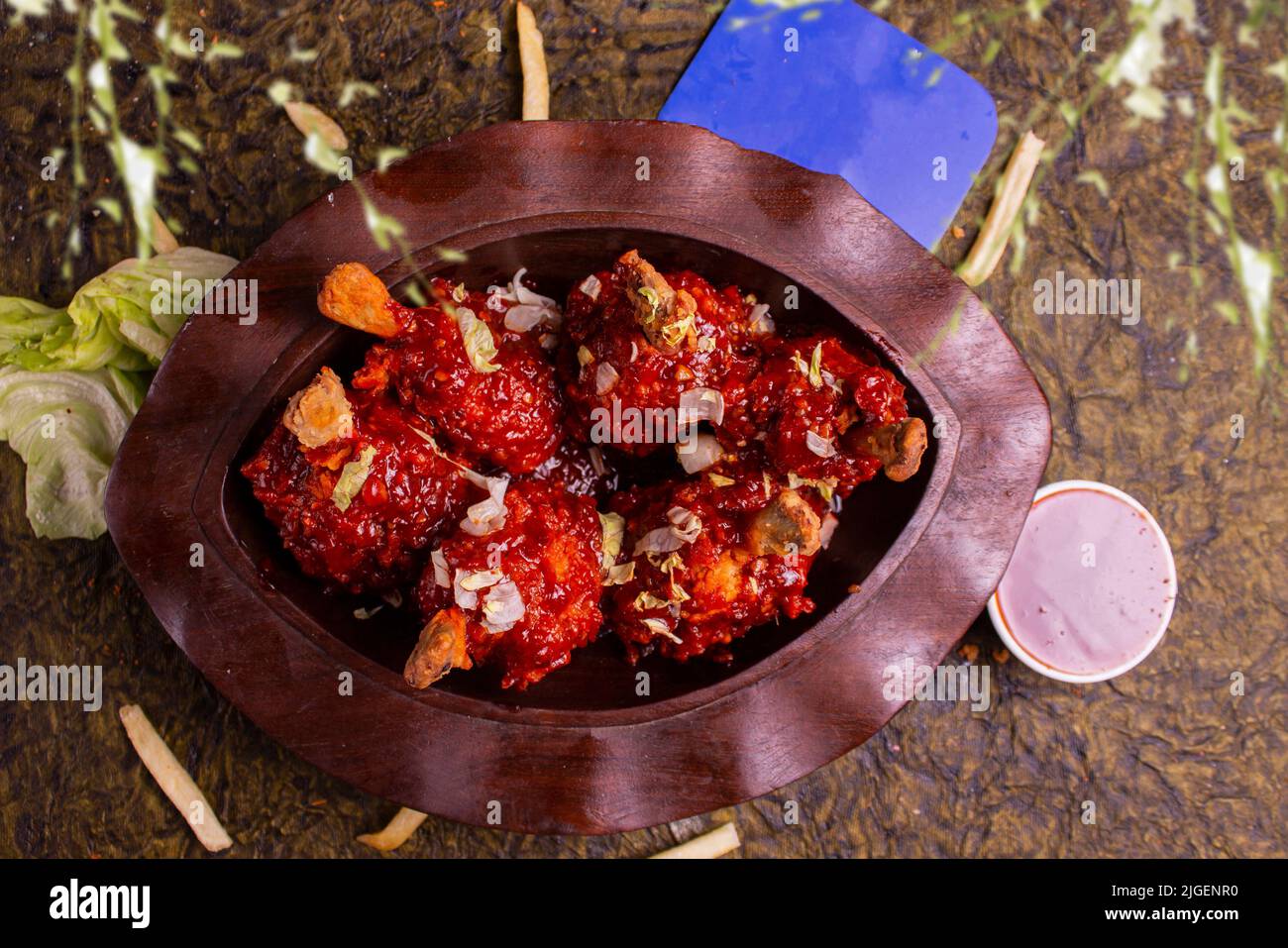 Szechuan Chicken, ein beliebtes indo-chinesisches nicht-vegetarisches Rezept. Serviert auf einem Teller mit Chilisauce. Selektiver Fokus. Copy Space. Stockfoto