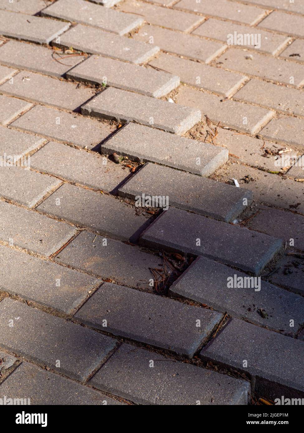 Schlaglöcher auf einem Bürgersteig, der von Menschen genutzt wird Stockfoto