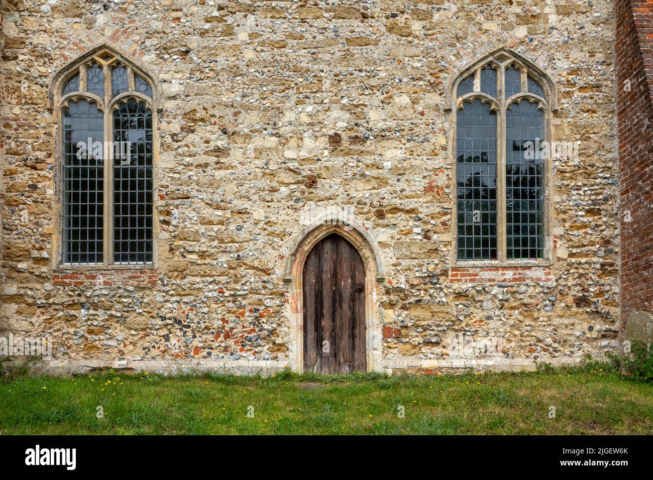 Details der St. Michael's Church Tunstall Suffolk mit einer kleinen Tür und schlichten Glasfenstern Stockfoto