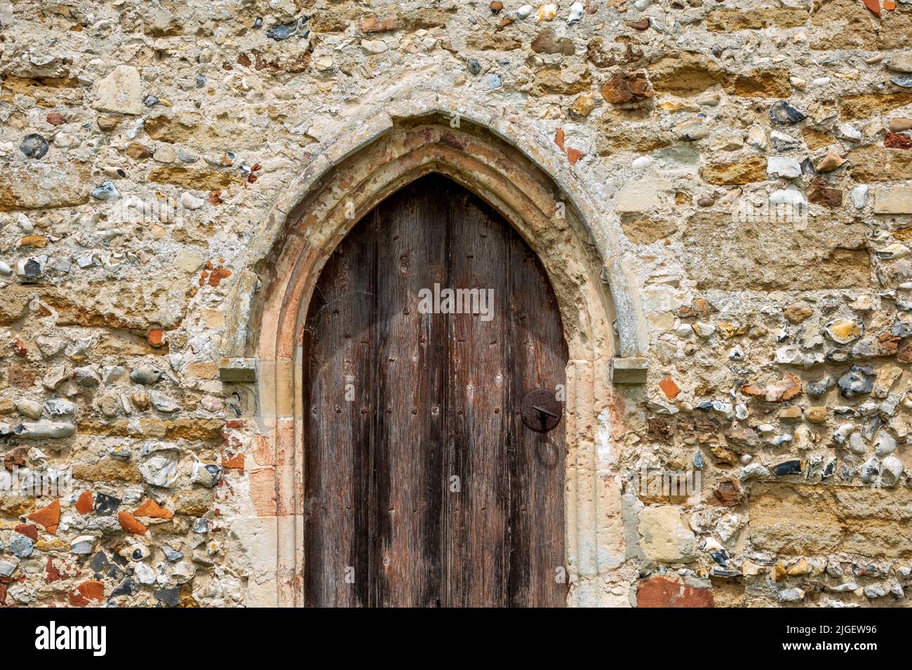 Details der St. Michael's Church Tunstall Suffolk mit einer kleinen Tür und schlichten Glasfenstern Stockfoto