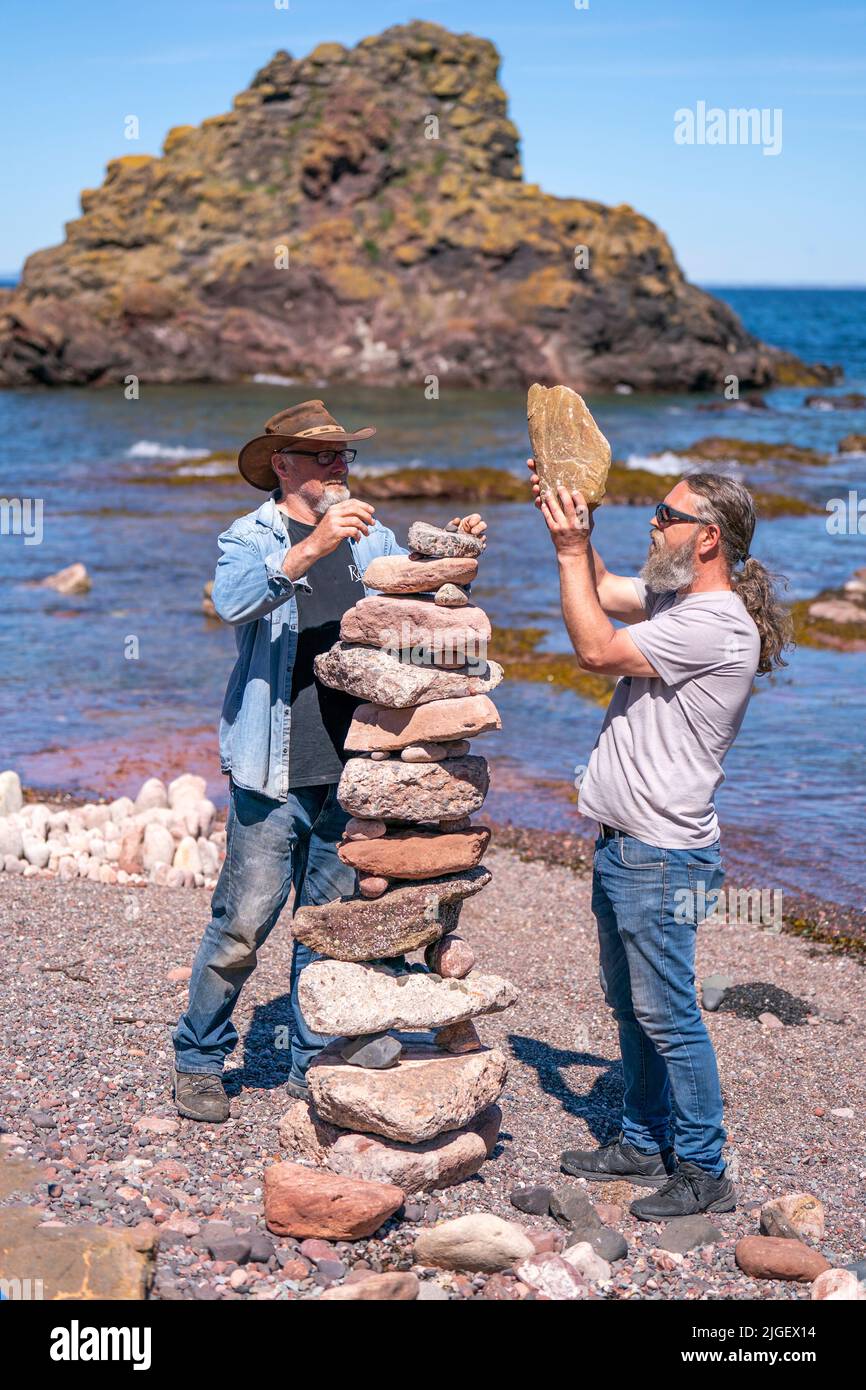 Die Teilnehmer nehmen an den European Stone Stacking Championships 2022 am Eye Cave Beach in Dunbar, East Lothian, Teil. Die Meisterschaften sind Europas größter Wettbewerb für alle Liebhaber und Künstler des Steinstapelns und des Felsausgleichs. Bilddatum: Sonntag, 10. Juli 2022. Stockfoto