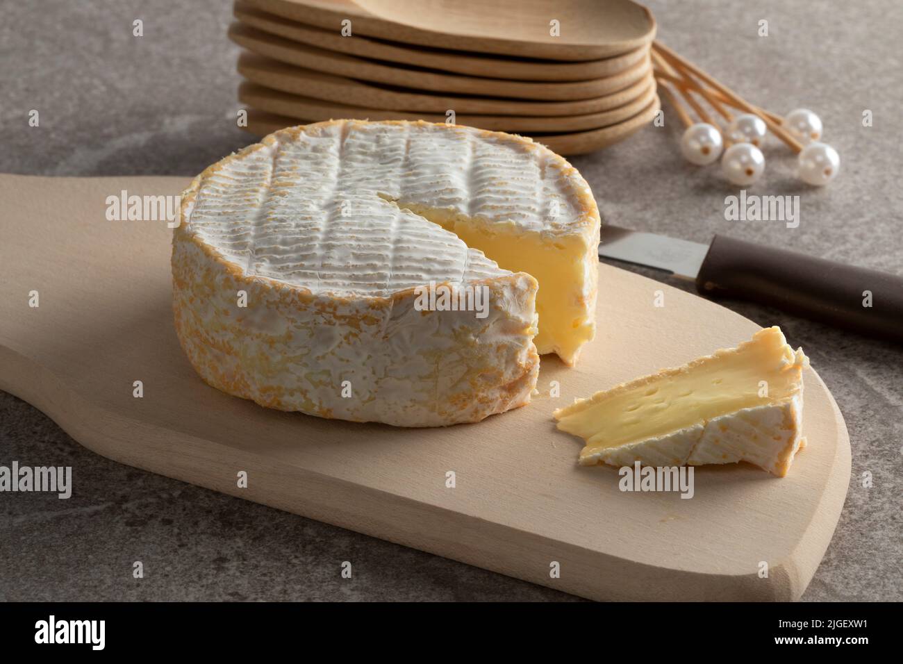 Weicher französischer Schafskäse und ein Stück auf einem Schneidebrett für einen Snack aus der Nähe Stockfoto
