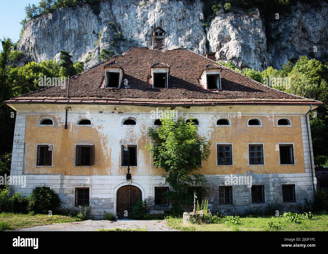 Altes verlassenes Haus in der Nähe eines Berges Stockfoto