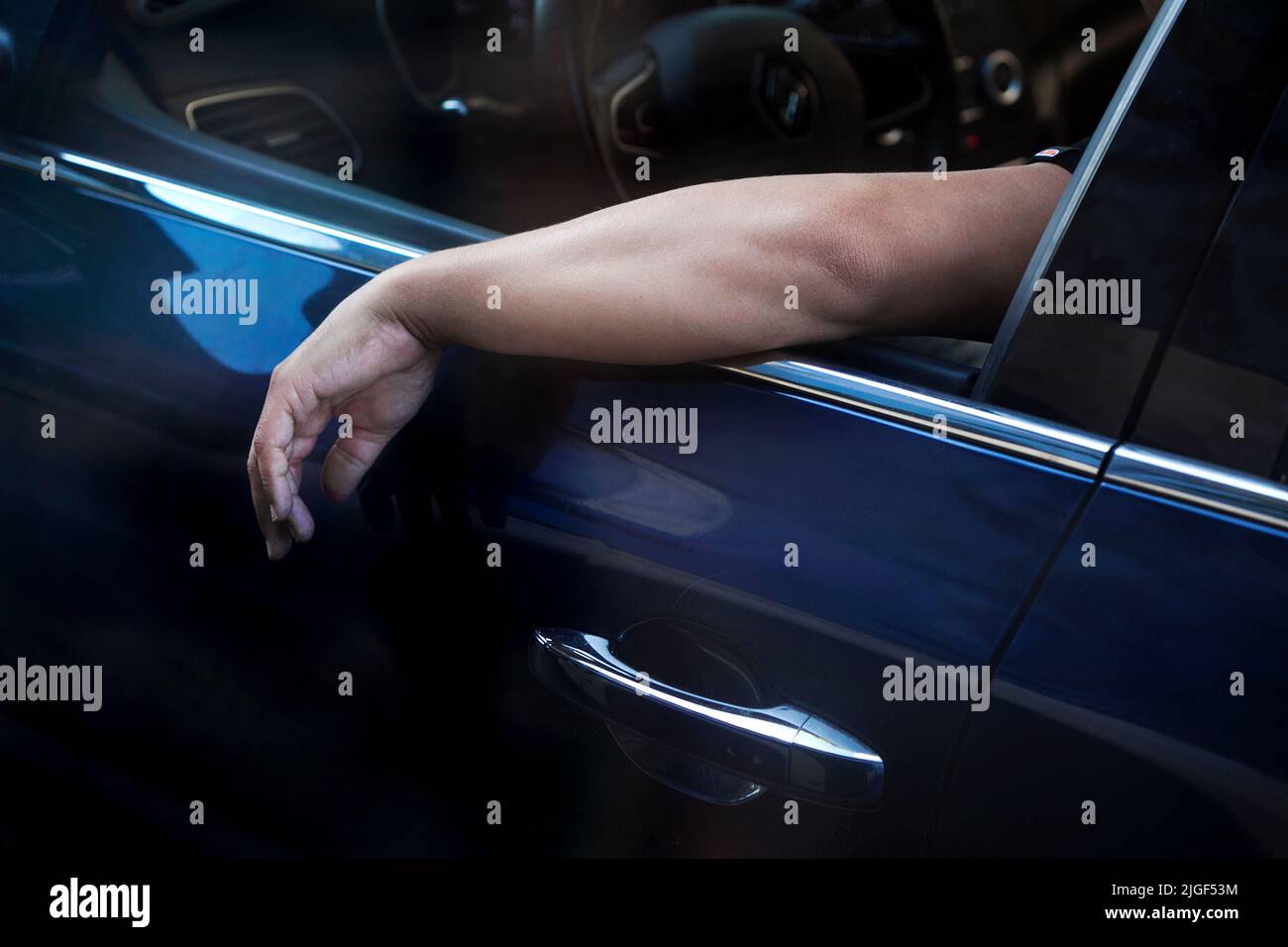 Der Arm des Mannes liegt auf der Fensterbank des Autos. Stockfoto