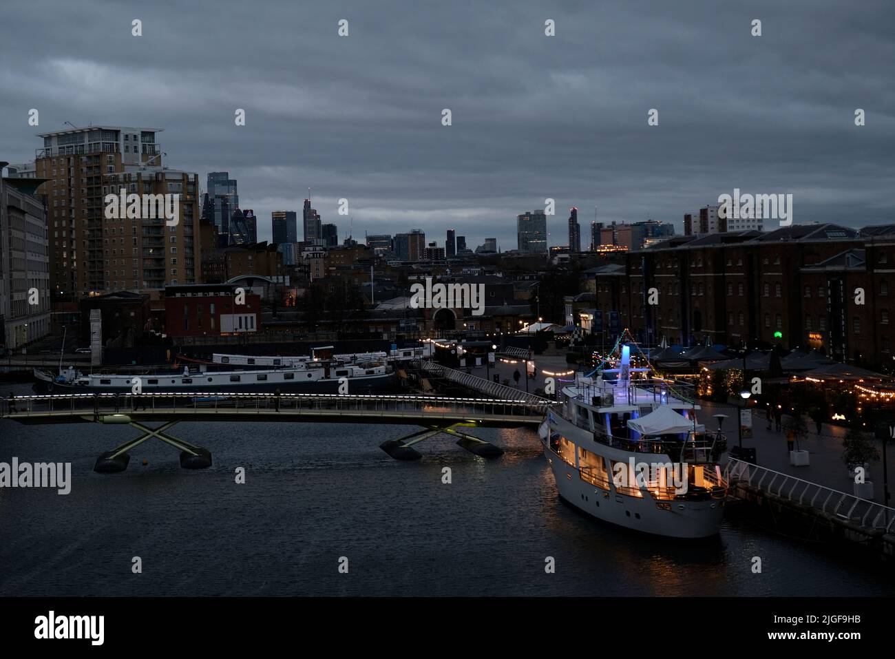 Das Boot wurde in der Abenddämmerung im North Dock von Canary Wharf in ein Hotel umgewandelt, mit dem Zentrum von London im Hintergrund Stockfoto