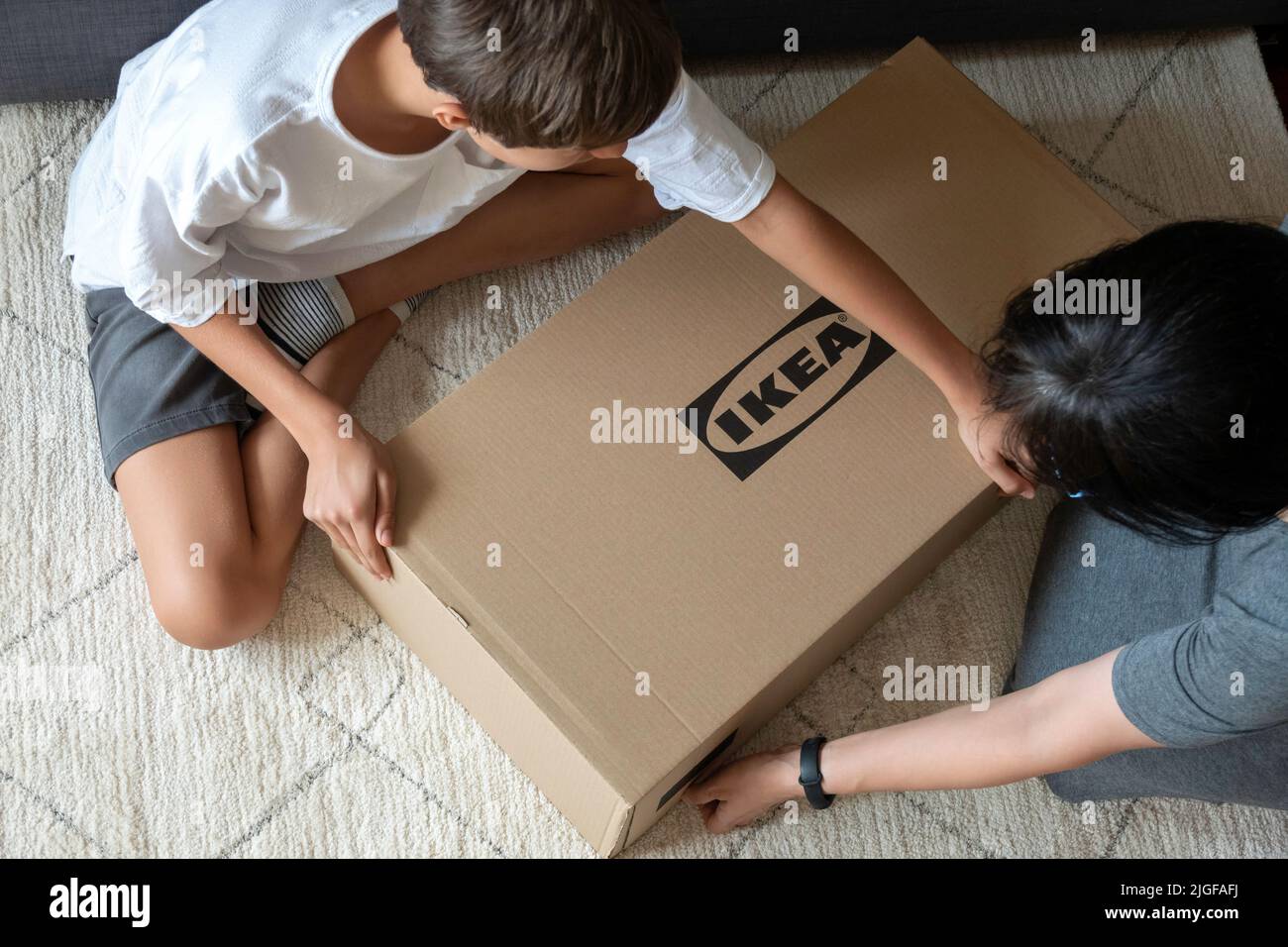 Vilnius, Litauen - 7. Juli 2022:Mutter und Kind stellen Ikea-Möbel zu Hause zusammen. IKEA ist ein schwedisch gegründeter, weltweit größter Möbelhändler Stockfoto