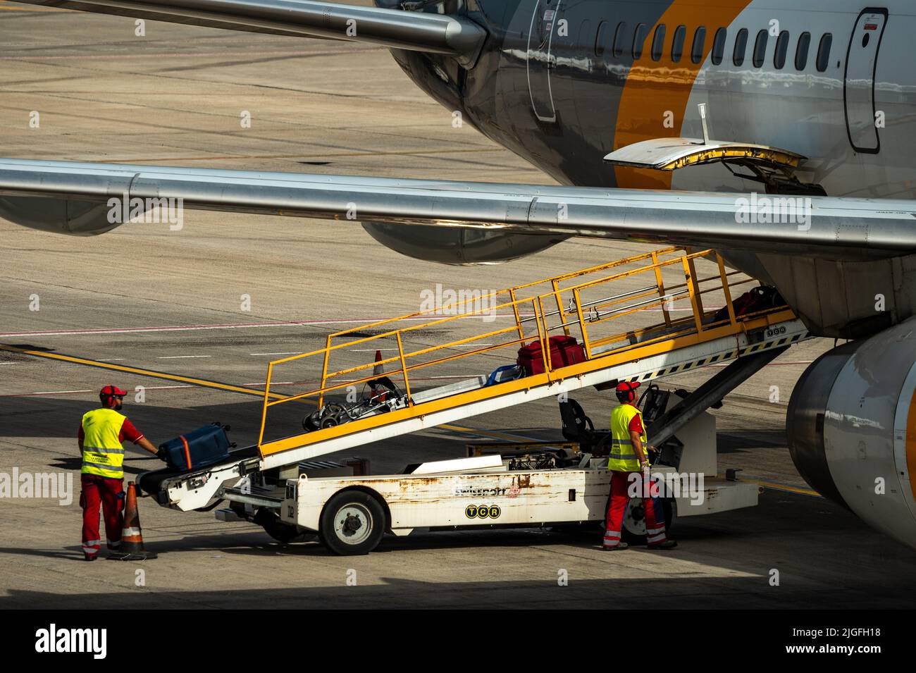 Auf dem Flughafen Cesar Manrique auf Lanzarote werden Flughafenmitarbeiter gesehen, wie sie Gepäck in ein Flugzeug laden. Stockfoto