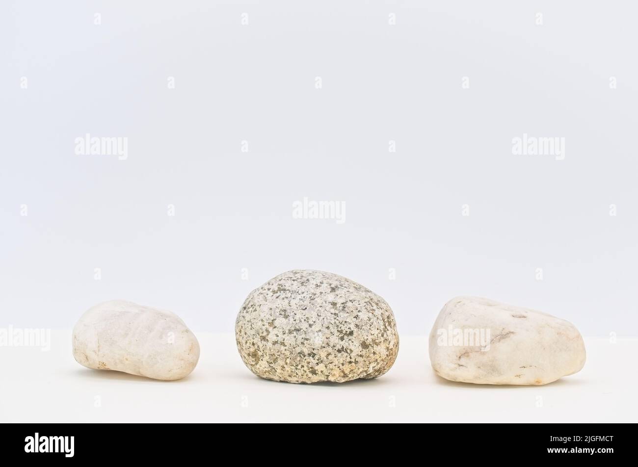 Runde Steine auf einem weißen Tisch mit Platz für Text Stockfoto