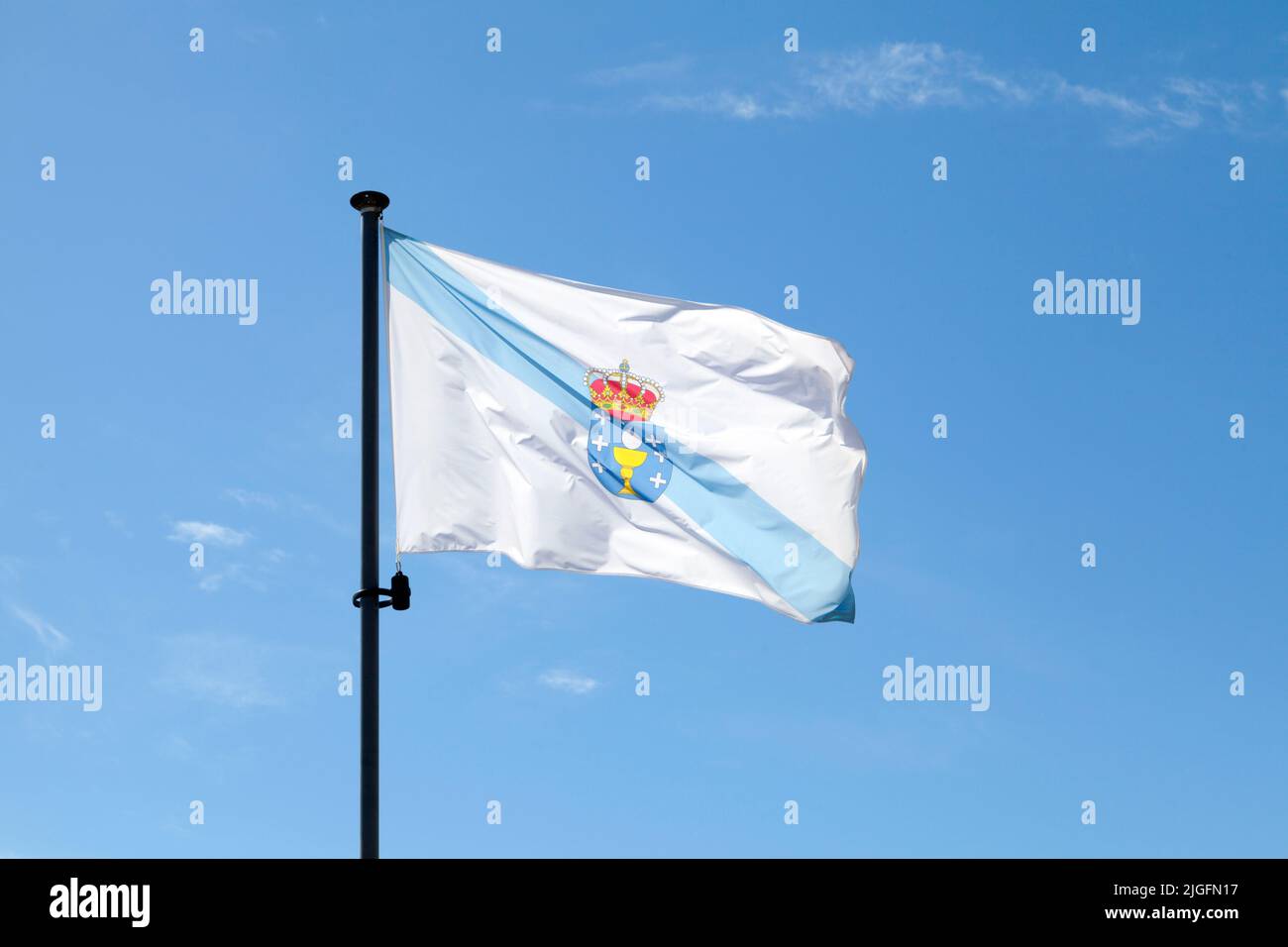 Die Flagge Galiciens winkt auf ihrem Pol gegen einen blauen Himmel. Stockfoto
