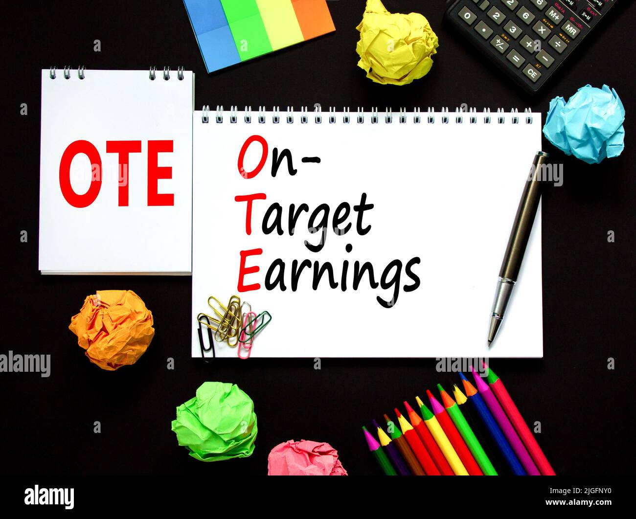 OTE-Symbol für die angestrebten Gewinne. Das Konzept formuliert die Zielgewinne des OTE auf weißem Ton auf einem schönen schwarzen Hintergrund. Rechner und Stift. Business und OT Stockfoto