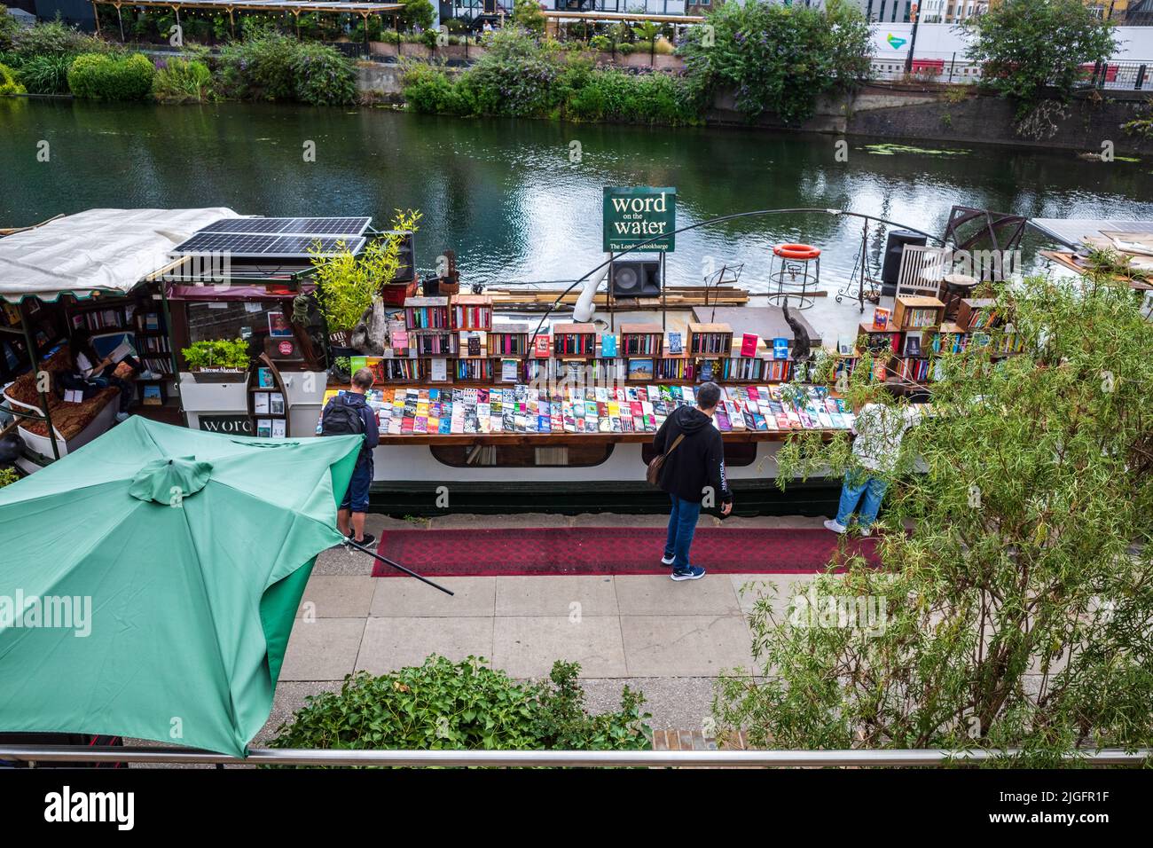 London schwimmende Buchhandlung am Regents Canal. Das schwimmende Bücherschiff „Word on the Water“ auf dem Londoner Regents Canal Towpath in der Nähe der Kings Cross Station. Stockfoto