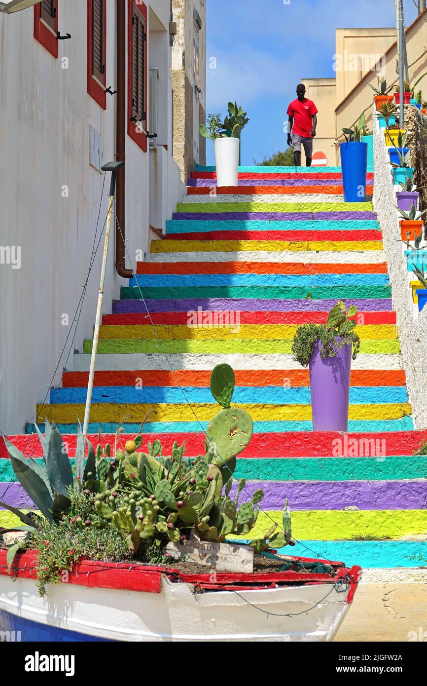 Farbige Treppe, die von der Stadt zum alten Hafen führt. Lampedusa, Italien - August 2019 Stockfoto