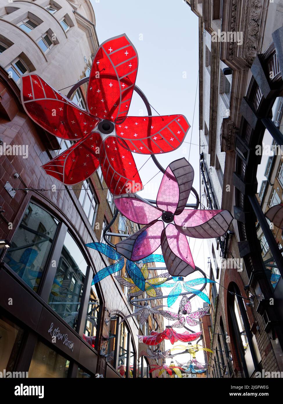 London, Greater London, England, Juni 15 2022: Bunte künstliche Blumen hängen in einer Straße neben der Floral Street im Convent Garden-Viertel. Stockfoto