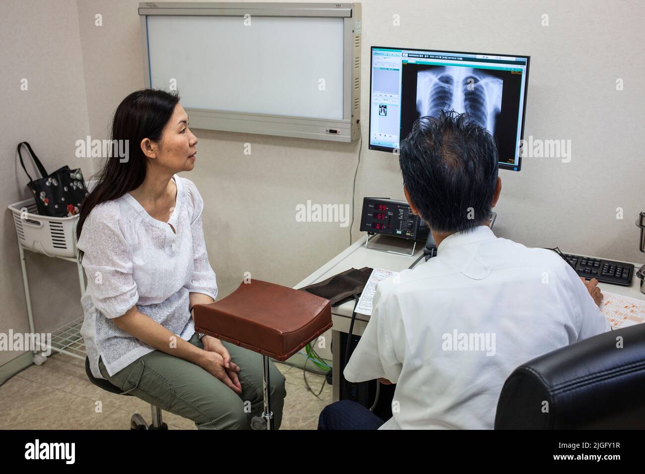 Der Arzt bespricht die Röntgenaufnahme der Patienten in der medizinischen Klinik in Ota, Tokio, Japan Stockfoto