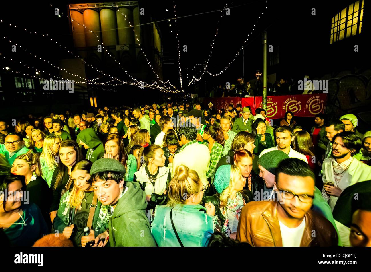 Eine Gruppe von trendigen jungen Leuten, die an einem Musikkonzert teilnehmen und Spaß in der Menge haben Stockfoto