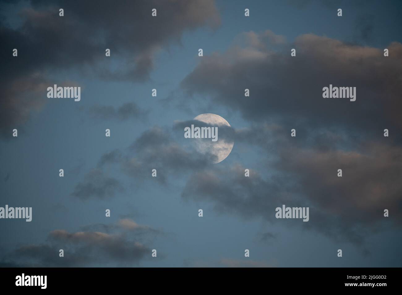 Der Mond guckt hinter Makrelenwolken Stockfoto