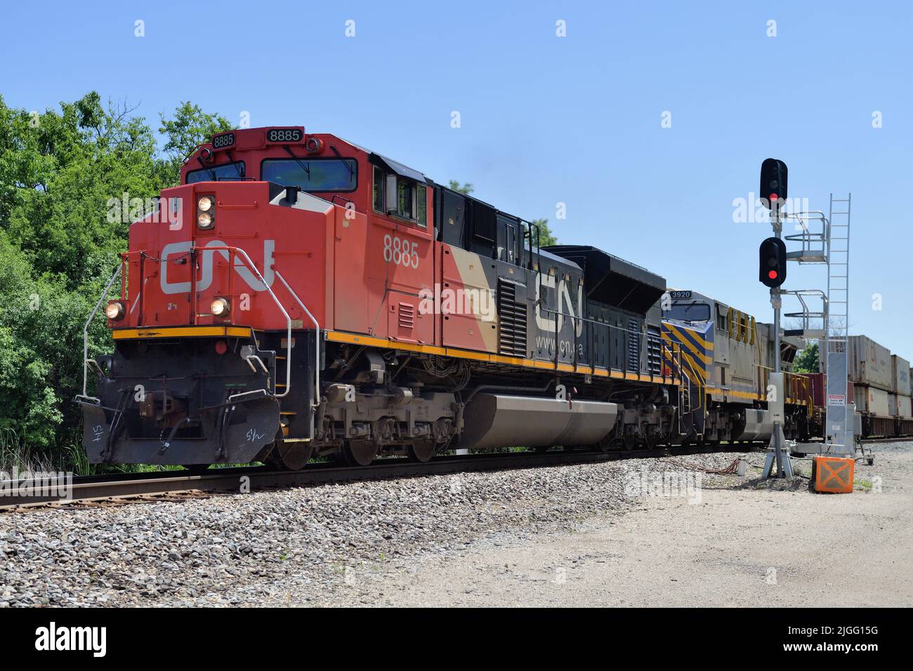 Dundee, Illinois, USA. Die Lokomotiven der Canadian National Railway führen einen intermodalen Güterzug durch einen vorbeifahrenden Abstellgleis. Stockfoto