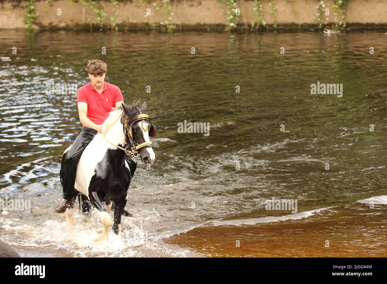 Ein junger Mann auf seinem Pferd im Fluss Eden, Appleby Horse Fair, Appleby in Westmorland, Cumbria Stockfoto