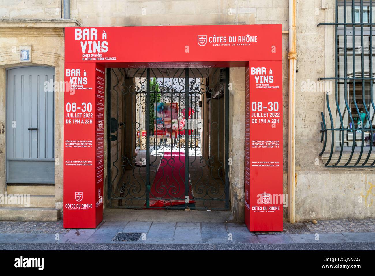 Ein auffallend roter Rahmen auf einem alten Stadthaus weist darauf hin: Drei Wochen lang werden in Avignon täglich Côtes du Rhône Weinproben durchgeführt. Avignon, Frankreich Stockfoto