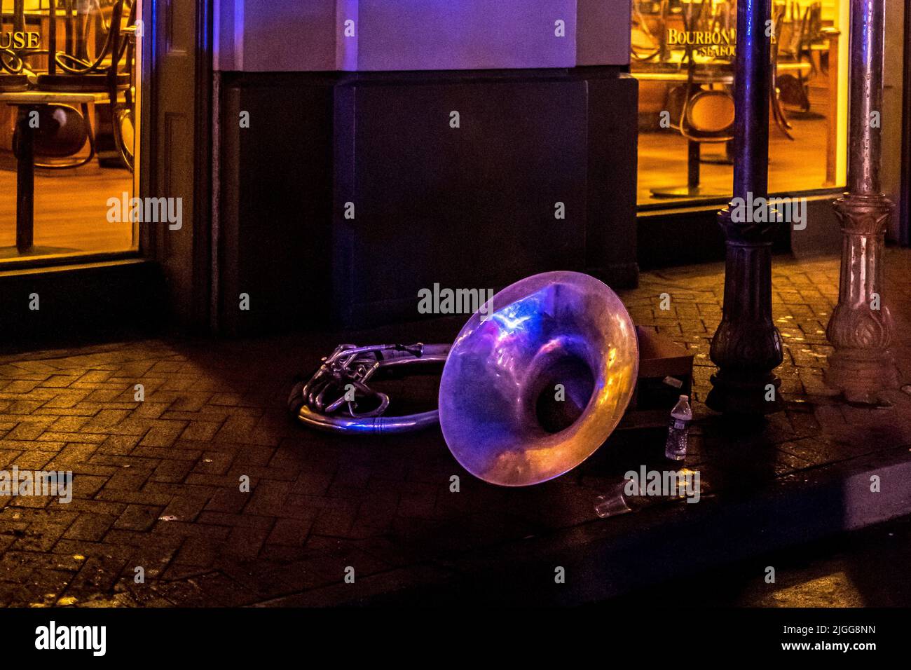 Bourboun Street in New Orleans (Louisiana) bei Nacht, zeigt eine Posaune, die von einem Künstler in der Nähe auf dem Boden gelassen wurde Stockfoto
