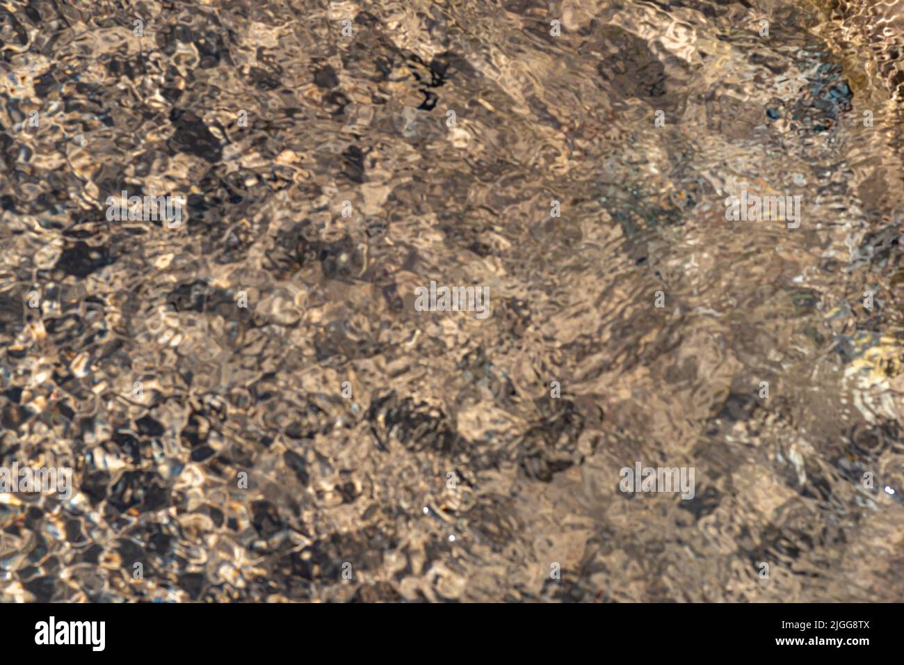 Verschwommener abstrakter beiger Hintergrund, Bach unten durch fließendes Wasser Stockfoto