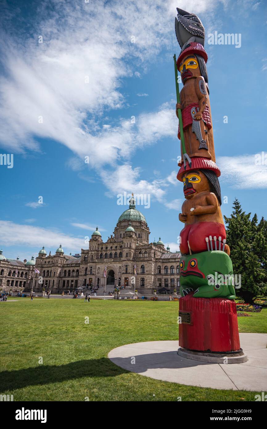 British Columbia Parliament Building, Victoria. Im Vordergrund ist ein Totem der First Nations zu sehen. Stockfoto
