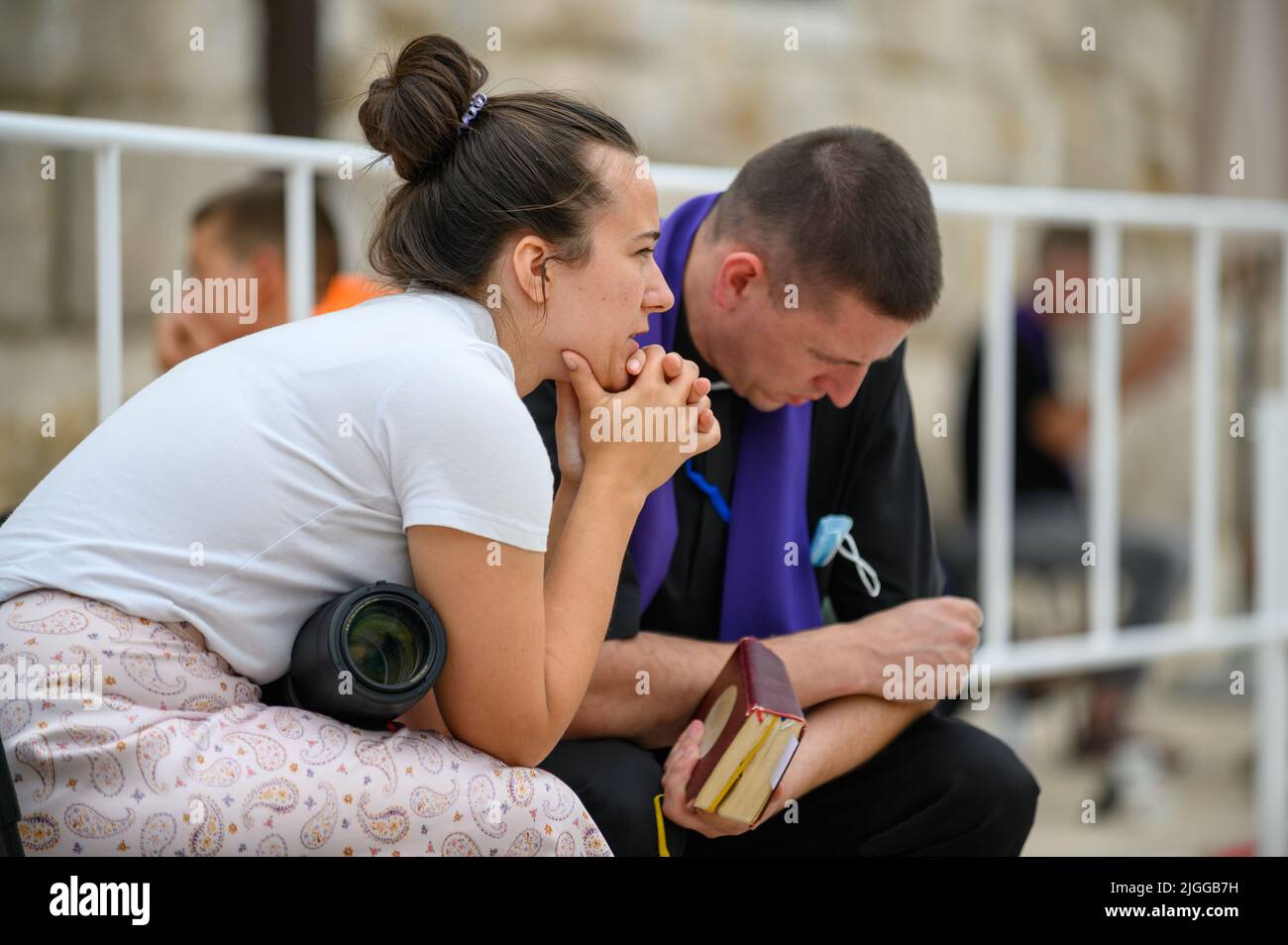 Katholische Beichte – eine Frau, die einem katholischen Priester beichtet – während des Mladifest 2021, dem Jugendfestival in Medjugorje. Stockfoto
