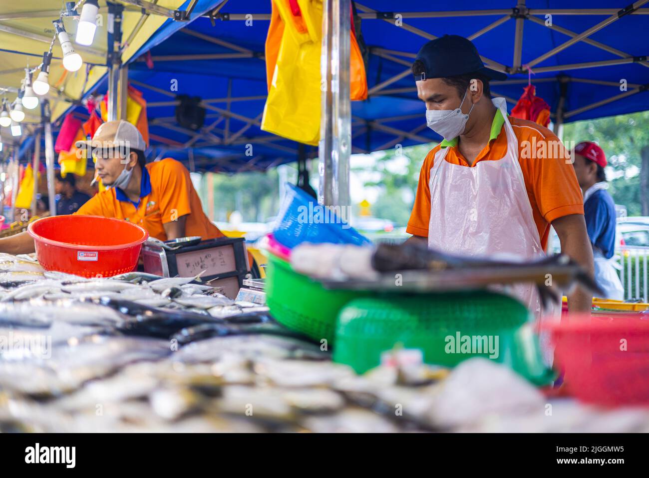 Kuala Lumpur, Malaysia - 21. Juni 2022: Fischverkäufer auf einem Frischmarkt in KL. Der Fischhändler verkauft seinen frischen Fang auf einem Nachtmarkt. Traditionelle Lebensmittelmarke Stockfoto