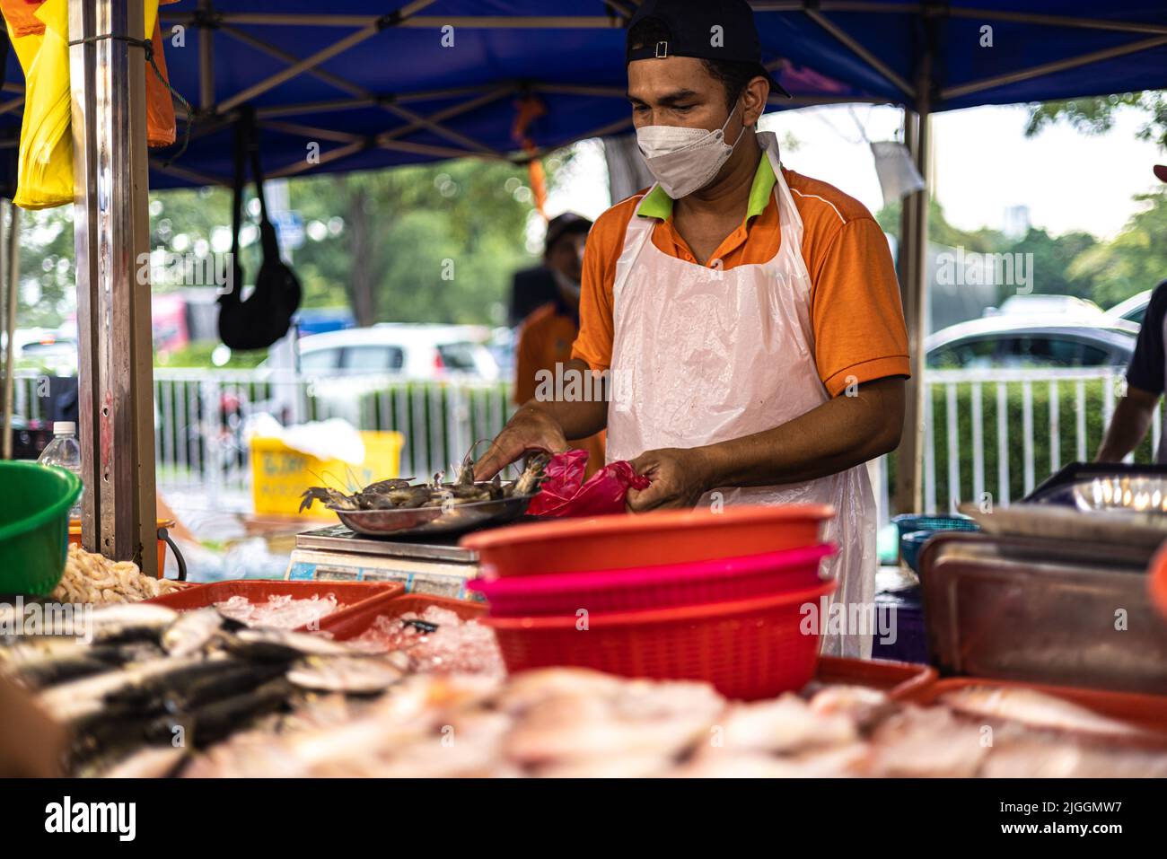Kuala Lumpur, Malaysia - 21. Juni 2022: Fischverkäufer auf einem Frischmarkt in KL. Der Fischhändler verkauft seinen frischen Fang auf einem Nachtmarkt. Traditionelle Lebensmittelmarke Stockfoto