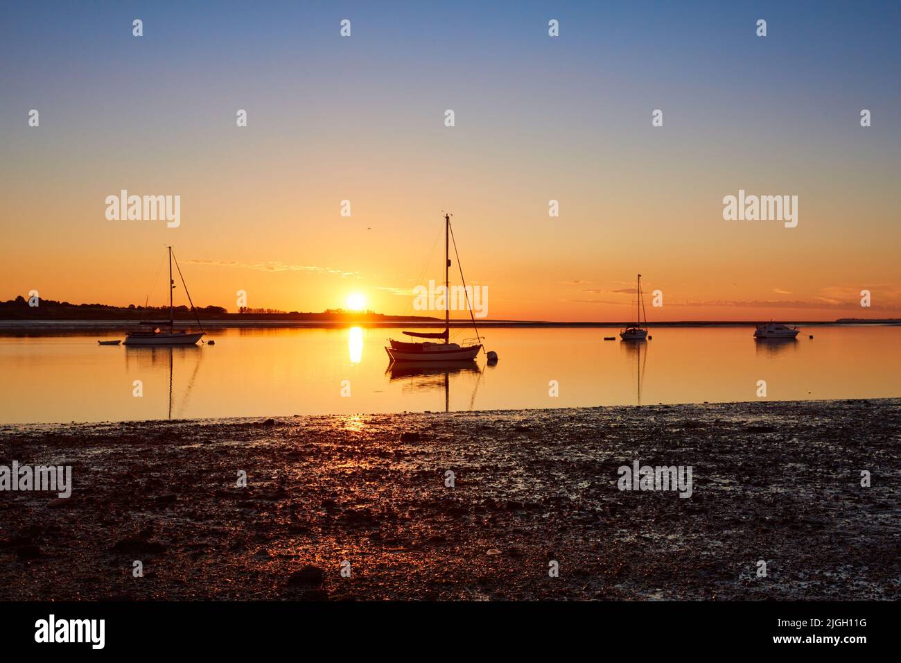 Swale Estuary, Kent, Großbritannien. 11.. Juli 2022: Wetter in Großbritannien. Ein heller, klarer Sonnenaufgang über Yachten, die in der Mündung des Swale bei Oare in Kent vor Anker liegen, während eine Woche heißer Temperaturen voraussichtlich bis Mitte 30s ansteigen wird. Kredit: Alan Payton/Alamy Live Nachrichten. Stockfoto