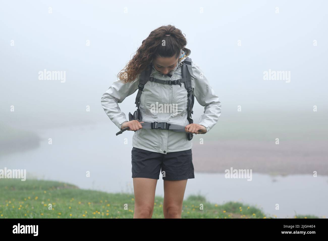 Vorderansicht Porträt eines Wanderers, der den Rucksackgurt im Berg justiert Stockfoto