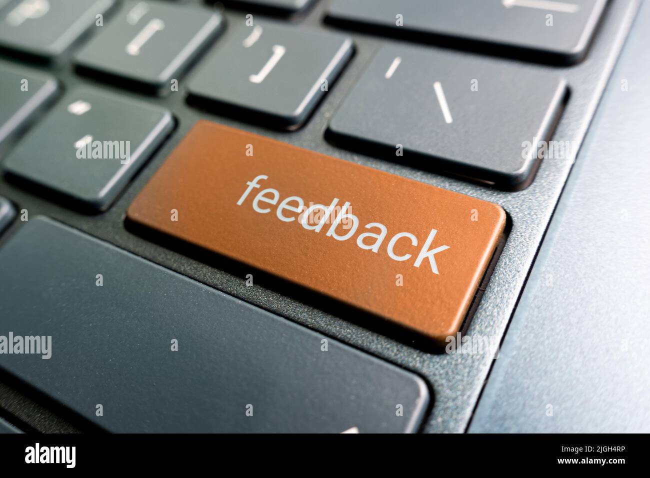 Drücken Sie die orangefarbene Feedback-Taste auf der Laptop-Tastatur Stockfoto