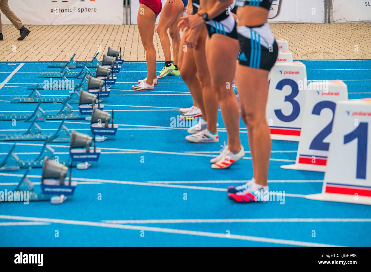 SAMORIN, SLOWAKEI, 9. JULI: Start des weiblichen Sprint-Rennens. Professionelle Leichtathletik-Veranstaltung. Starte Blöcke und Beine von weiblichen Athleten. Sprint auf Blau Stockfoto