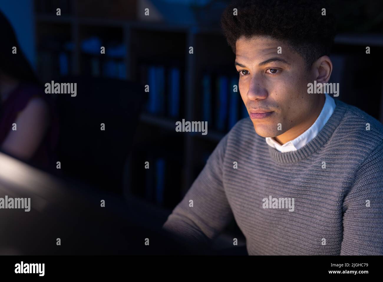 Seriöser asiatischer Geschäftsmann, der während der Arbeit spät in der Nacht im Büro einen Computer verwendet Stockfoto