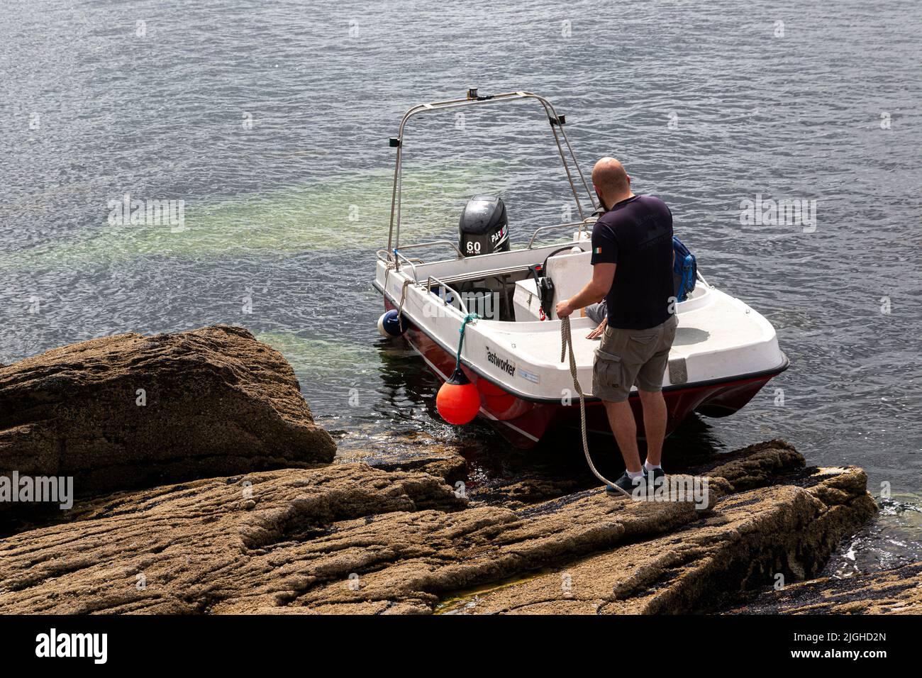 Kleines Fastworker Shallow Draft Boat, das an den Rocks auf Beginish Island, in der Nähe von Valentia County Kerry, Irland, festgemacht ist Stockfoto
