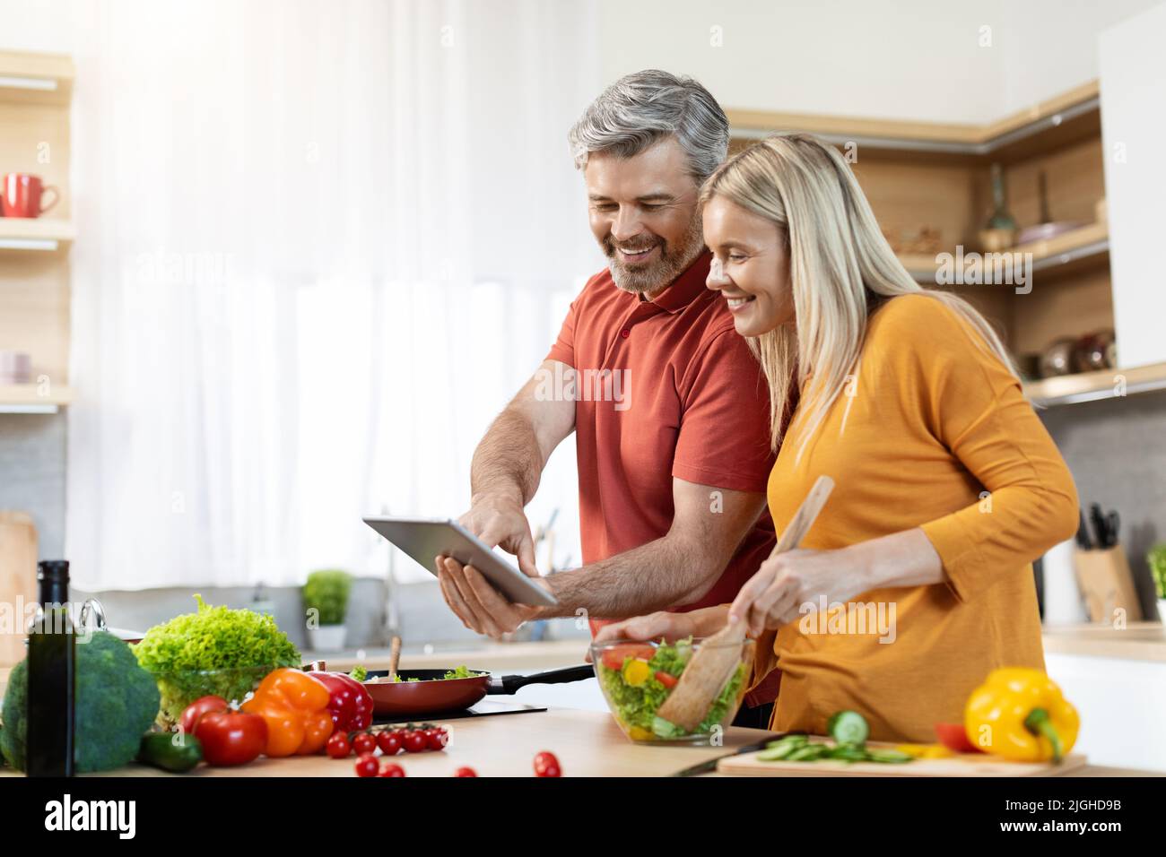 Schönes Paar Kochen gesundes Abendessen, überprüfen Rezepte online Stockfoto