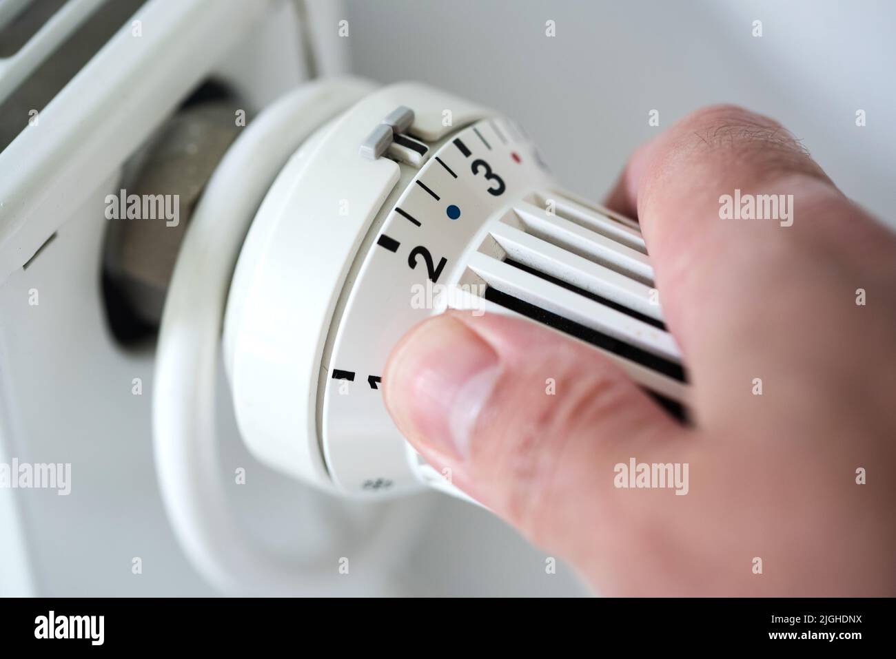 Person, die Thermostat am Heizkörper auf Temperatur zu senken, spart Energie und Geld Konzept Stockfoto Person, die Thermostat am Heizkörper auf Temperatur zu senken, spart Energie und Geld Konzept Stockfoto