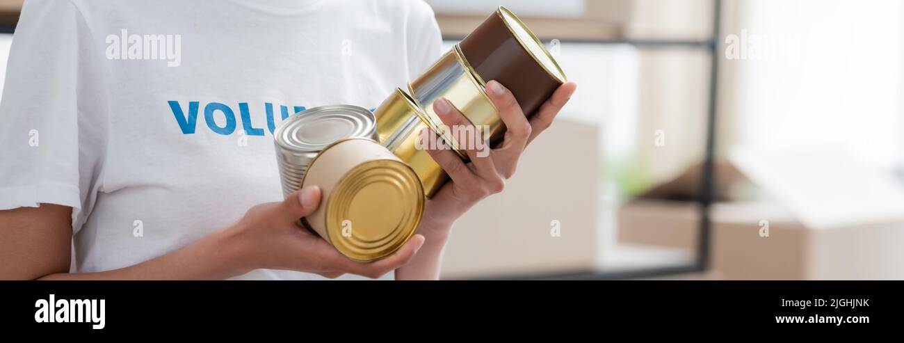 Beschnittene Ansicht eines afroamerikanischen Freiwilligen, der Lebensmittel aus der Dose hält, Banner Stockfoto