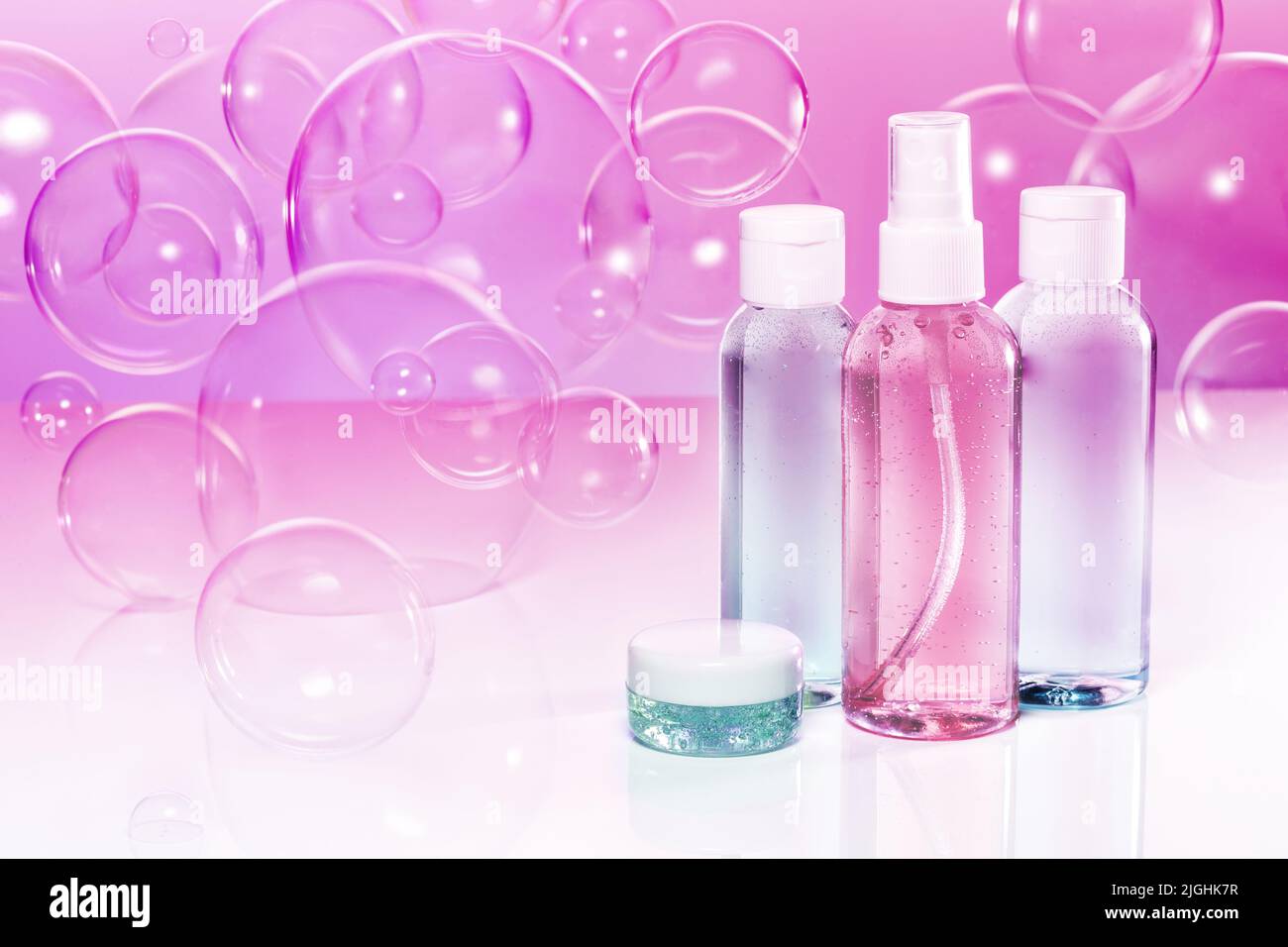 Set von Toilettenartikeln und Seifenblasen auf violettem Rosenhintergrund Stockfoto