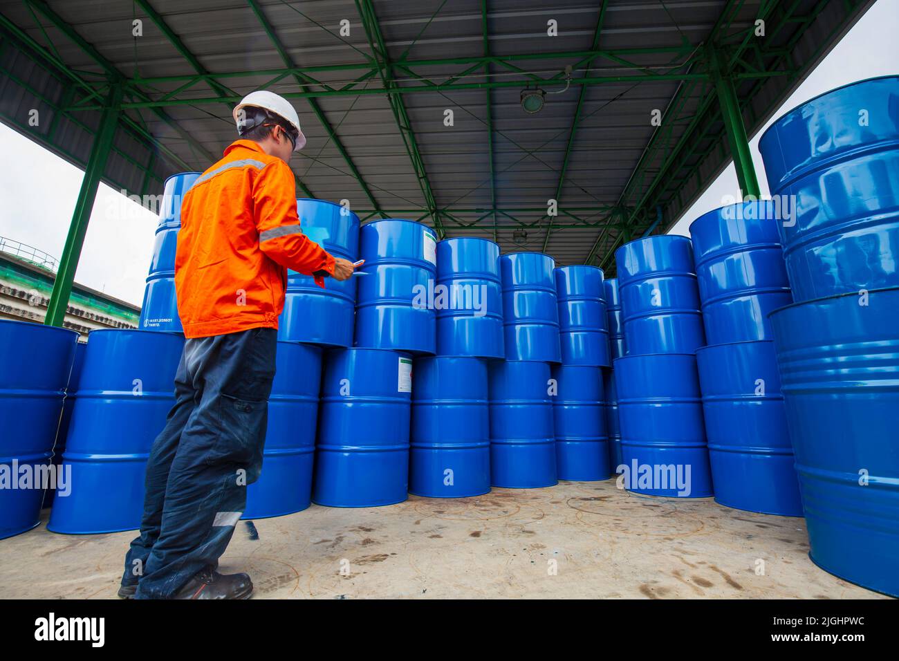 Männliche Arbeiter Inspektion Rekord Fass Öl Lager Fässer blau horizontal oder chemisch für in der Industrie. Stockfoto