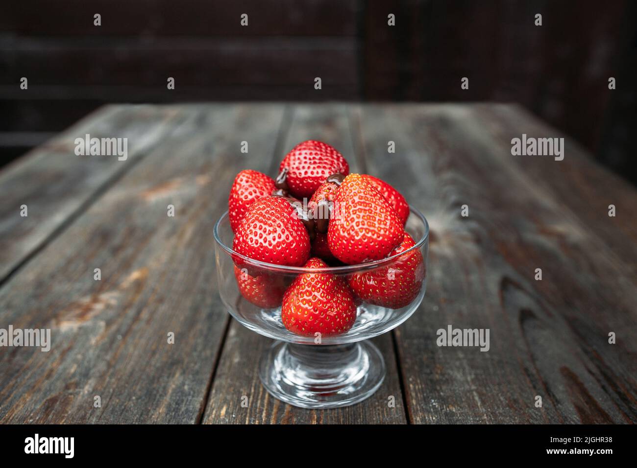 Erdbeere mit Schokoladenüberzug auf Holztisch Stockfoto