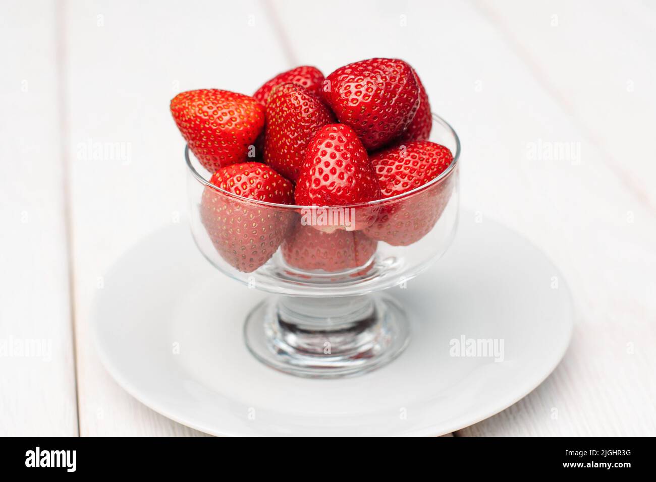 Glaskasse mit Erdbeeren auf weißem Hintergrund Stockfoto