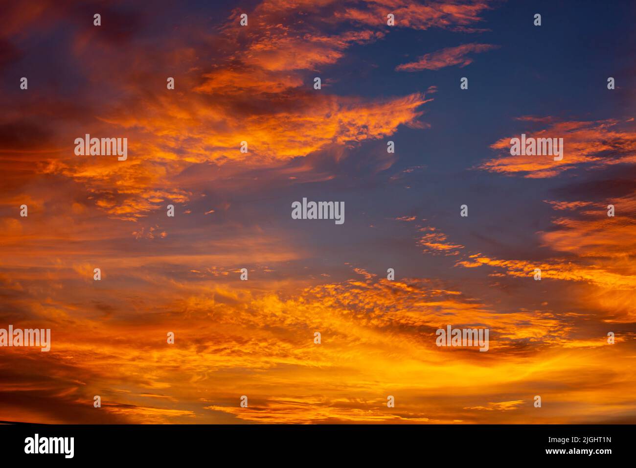 Orangefarbenes Himmellicht, das warm von der Sonne ist, verleiht den Wolken einen schönen Glanz Stockfoto