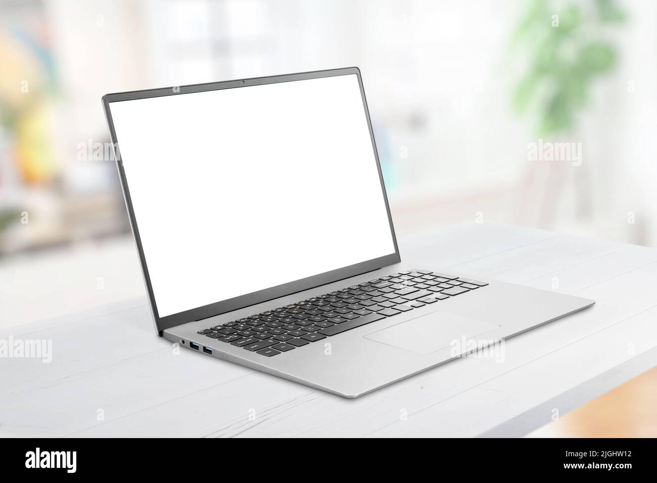 Laptop-Modell auf dem Schreibtisch. Isolierter Bildschirm für die Werbung auf einer Webseite. Sauberer Flachbildfernseher. Iluminated Büro im Hintergrund Stockfoto