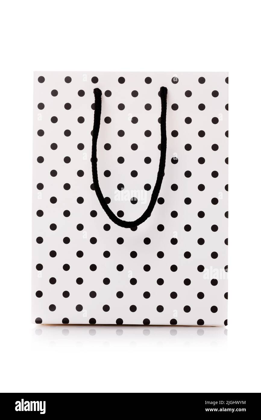 Einkaufstasche. Weißes Paket zum Einkaufen oder Geschenke mit schwarzen Punkten und Griffen. Konzept von Geschenken für Geburtstag, Frauentag, Muttertag. Isoliert auf w Stockfoto